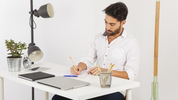 man wirting on clipboard