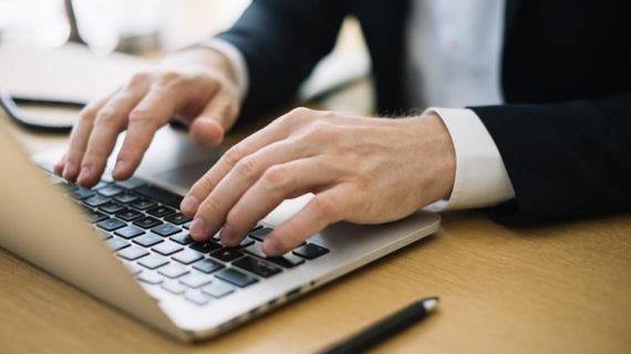 man typing on his laptop