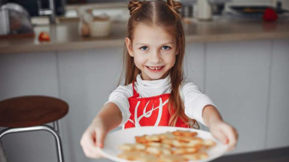 adorable little girl holding plate of cookies