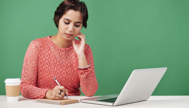 adult woman thinking while writing