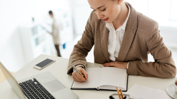 adult female employee writing on her notebook