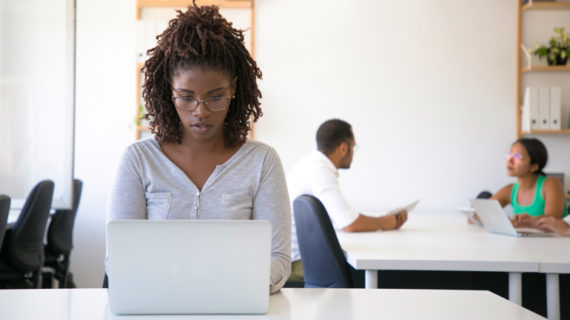 beautiful black woman working using her silver laptop