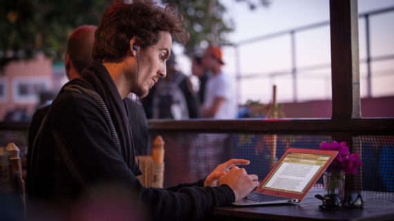 man working on the cafe using his laptop