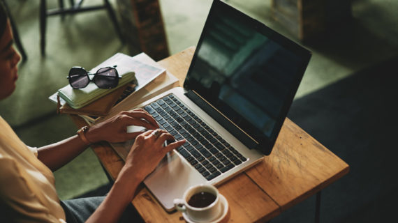 woman sitting in cafe and working on laptop