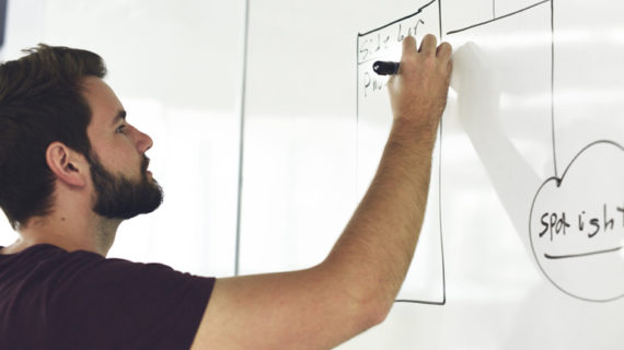 man holding black pen wearing black crew-neck