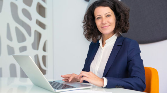 Happy businesswoman working with her laptop