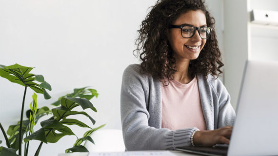 Happy writer working with her laptop