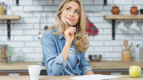 Woman thinking and listing down in her notes