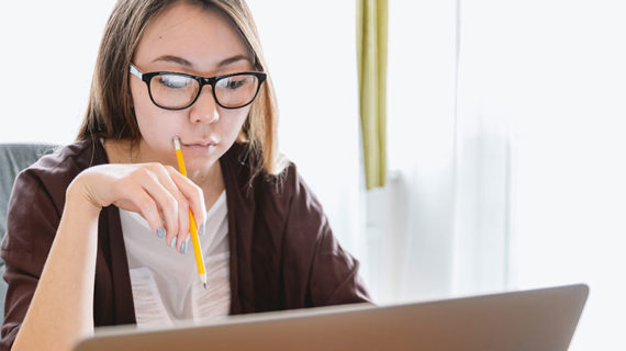 Woman reading notes on her laptop