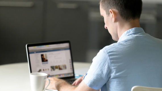 young man working at desk with laptop