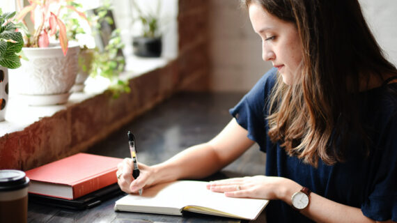 woman writing on her notebook