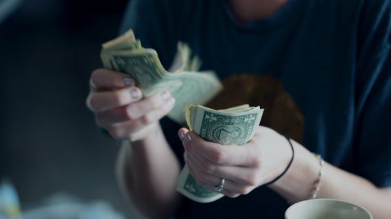 woman counting dollar bills