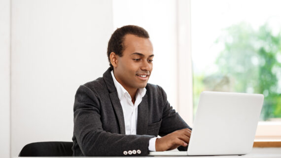 Young successful businessman typing on laptop