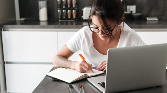 Concentrated serious young woman using laptop