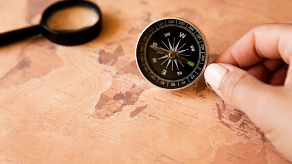 hand holding a compass on a map