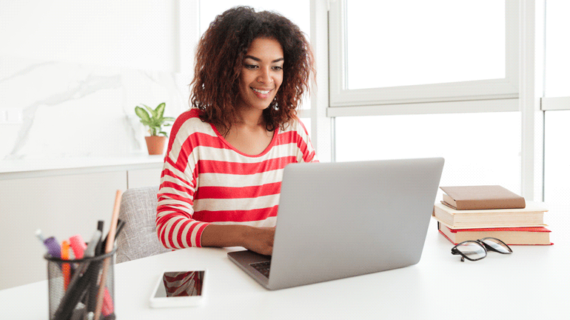 cheerful woman using silver laptop