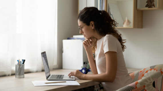 Concentrated Young Woman Working on Computer in Modern