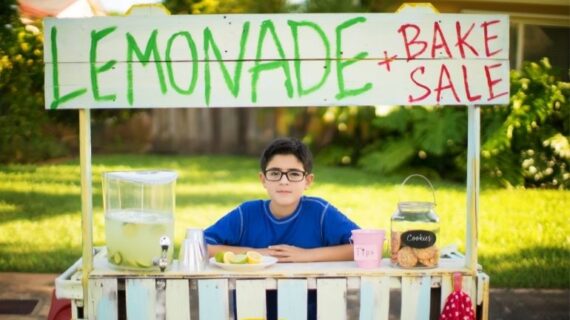 boy wearnig blue shirt selling lemonade