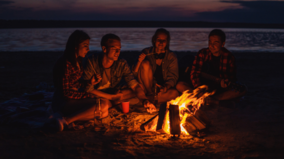 group of people having bonfire near the beach