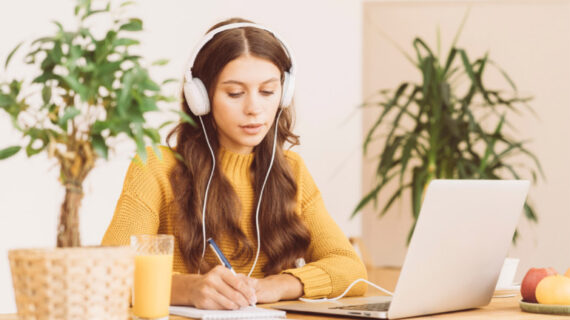 happy female in wireless headphones studying online course