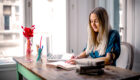 woman blue long-sleeve shirt sitting at the table working