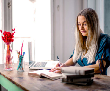 woman blue long-sleeve shirt sitting at the table working