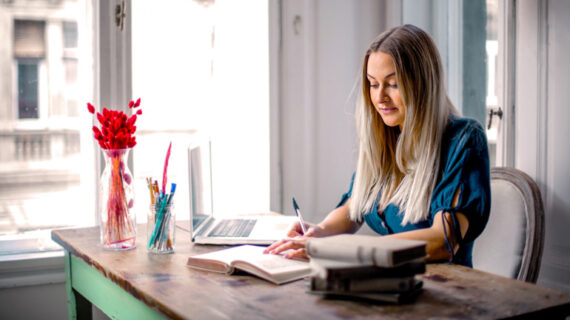 woman blue long-sleeve shirt sitting at the table working