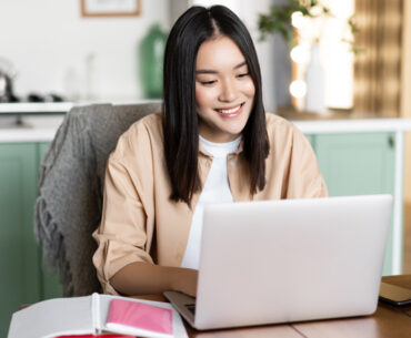 Woman having video chat online school on computer smiling at laptop