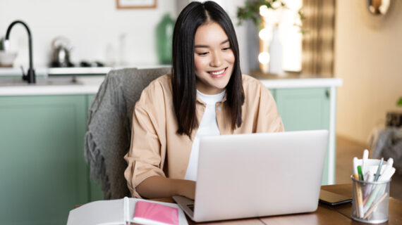 Woman having video chat online school on computer smiling at laptop