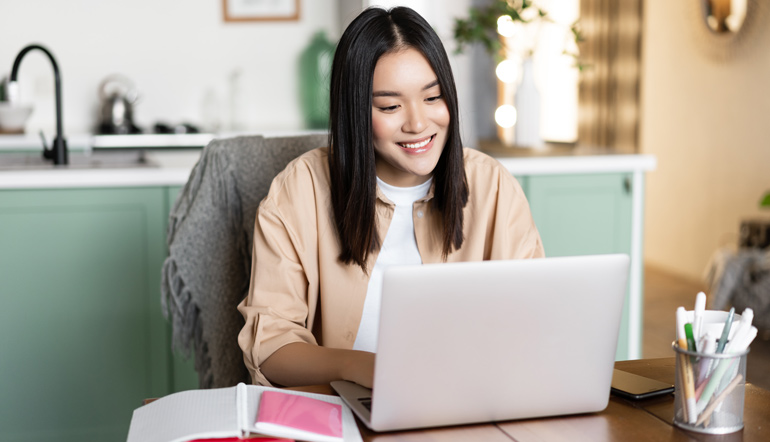 Woman having video chat online school on computer smiling at laptop