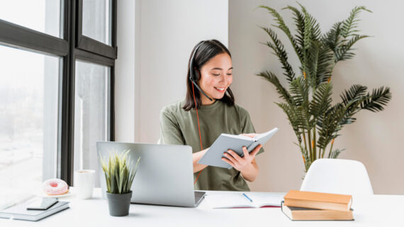 Woman with headset having video call on laptop