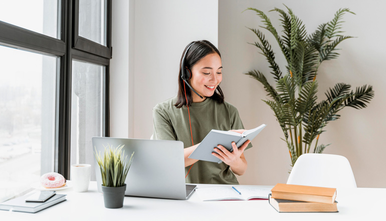 Woman with headset having video call on laptop