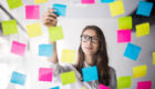 Young girl business woman in glasses watch on transperent wall