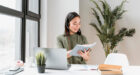 Woman with headset having video call on laptop